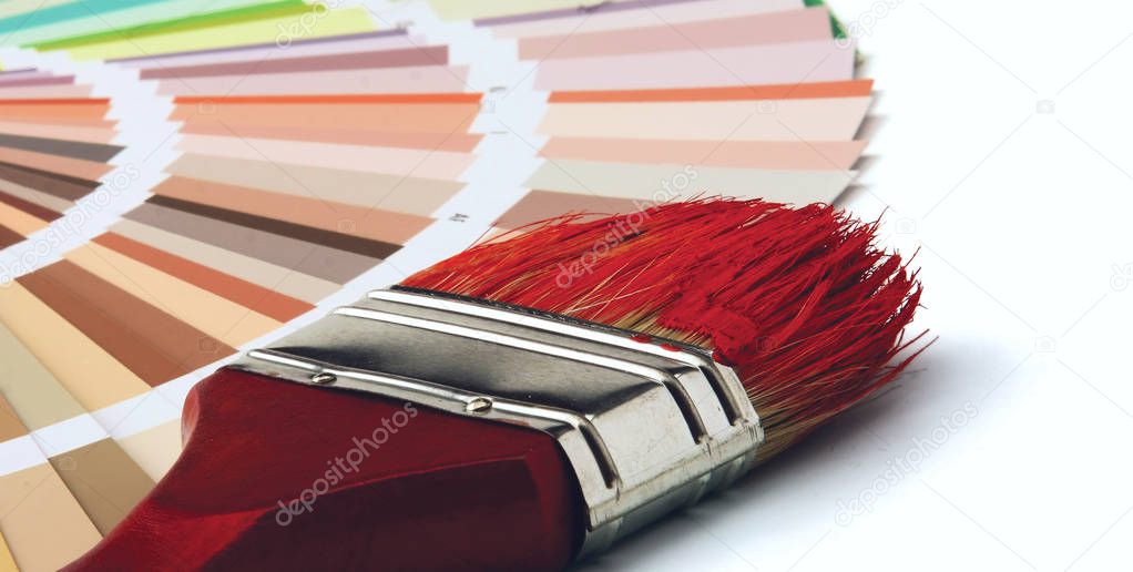 Close-up of a color palette and a brush on white background