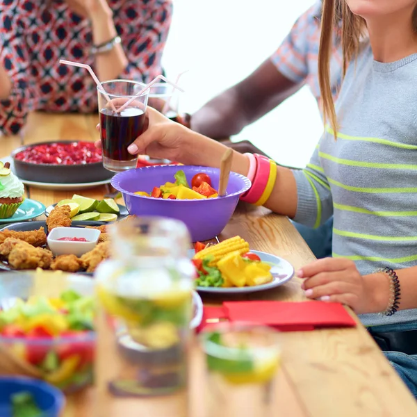 Gruppe von Menschen beim gemeinsamen Abendessen am Holztisch — Stockfoto