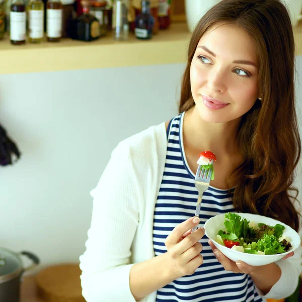 Young woman eating salad and holding a mixed salad — Stock Photo, Image