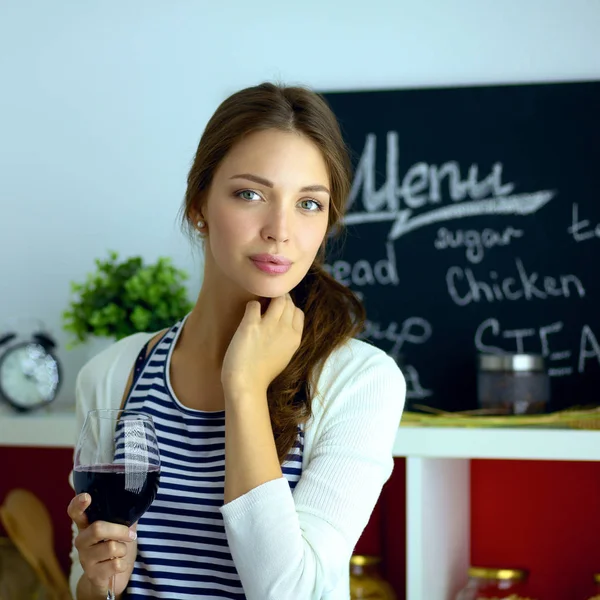 Hübsche Frau trinkt zu Hause Wein in Küche . — Stockfoto