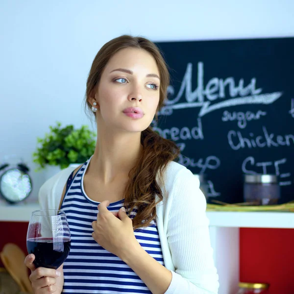 Hübsche Frau trinkt zu Hause Wein in Küche . — Stockfoto