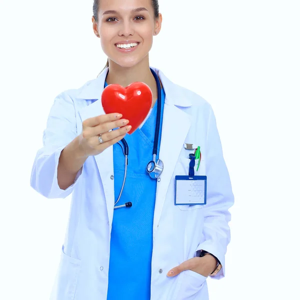 Pozytywne kobiety lekarz stojący ze stetoskopem i czerwony symbol serca izolowane — Zdjęcie stockowe