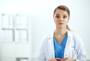 Kadın doktor hastanede dosyayla bekliyor.