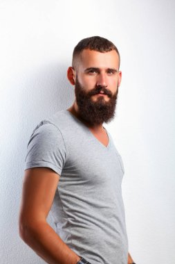 Ayakta, gri arka plan üzerinde izole yakışıklı adam portresi