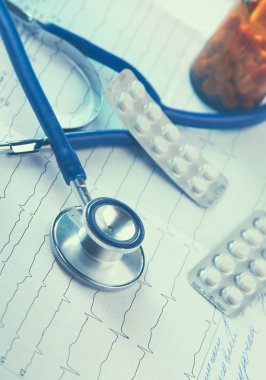 Kardiyogramda yığınla tıbbi steteskop var.