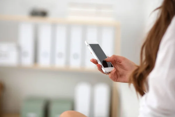 Geschäftsfrau verschickt Nachricht mit Smartphone im Büro — Stockfoto