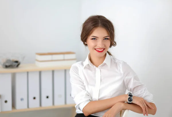 Empresária atraente sentada na cadeira no escritório — Fotografia de Stock