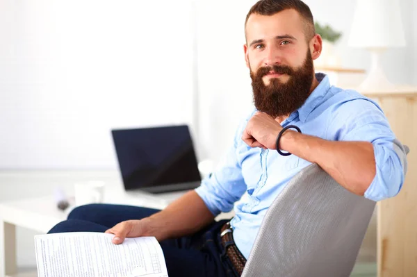 Fiatal üzletember ül széken az irodában — Stock Fotó