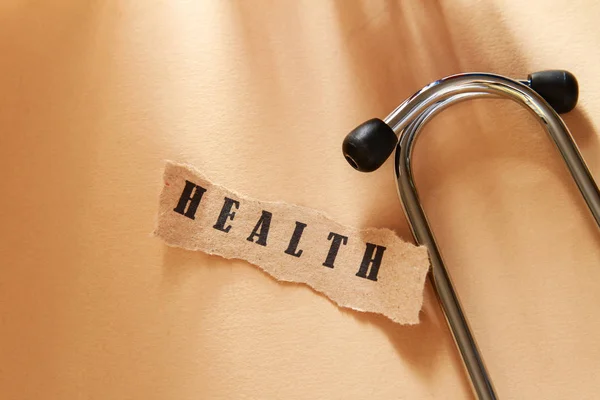 Word medical written on a ripped piece of paper and astethoscope — Stock Photo, Image