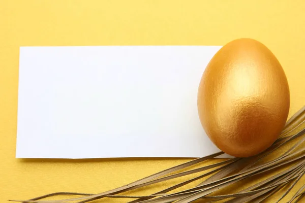 Golden egg on yellow background — Stock Photo, Image