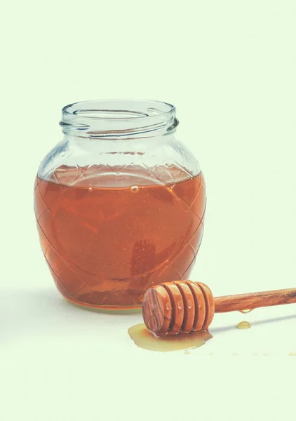 Skleněný džbán plný dřevěná naběračka medu — Stock fotografie