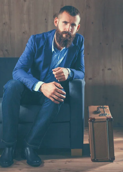 Geschäftsmann auf dem Sofa in der Büro-Lobby, isoliert auf dunklem Hintergrund — Stockfoto