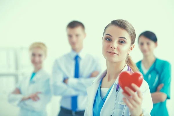 Fiatal nő orvos kezében egy piros szív, elszigetelt fehér alapon — Stock Fotó