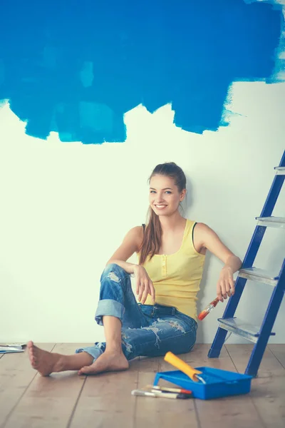 Portrét ženy malíře sedí na podlaze blízko zdi po malování — Stock fotografie