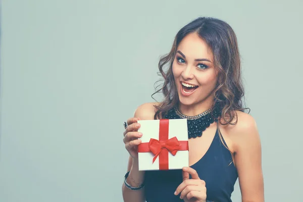 Mujer joven sonrisa feliz celebrar caja de regalo en las manos, aislado sobre fondo gris — Foto de Stock