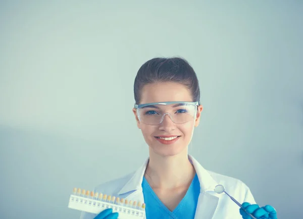 Giovane dentista con strumento su sfondo bianco — Foto Stock