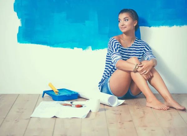 Retrato de pintora sentada en el suelo cerca de la pared después de pintar —  Fotos de Stock