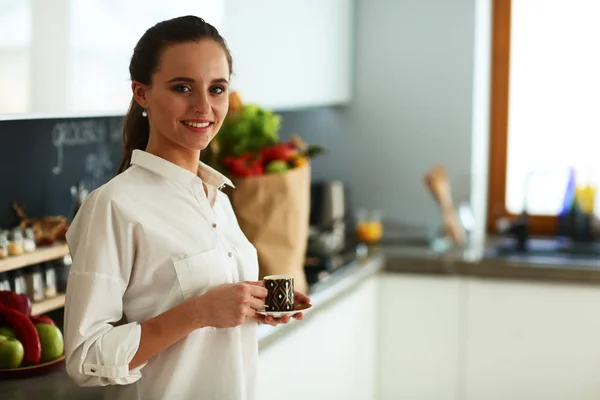 Mujer feliz bebiendo té en la cocina en casa —  Fotos de Stock