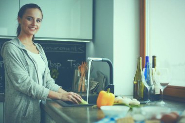 Güzel genç kadın mutfakta dururken salata sebze yıkama