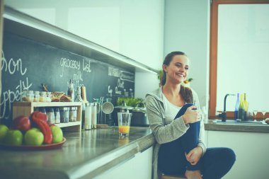 Mutfakta masada oturan genç bir kadın. .