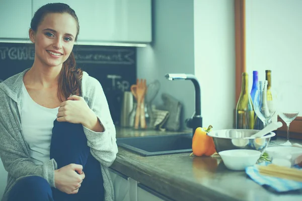 Young woman sitting a table in the kitchen . — Stock Photo, Image