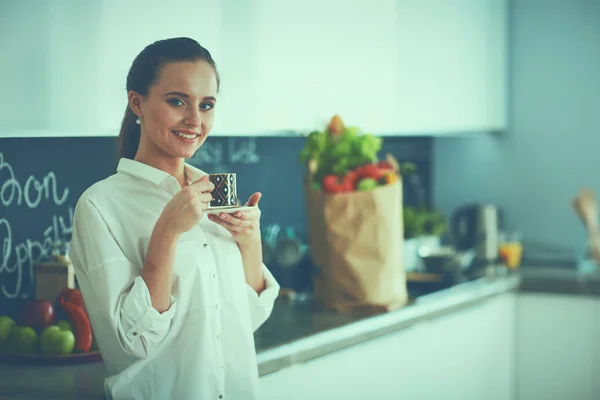 Mujer feliz bebiendo té en la cocina en casa — Foto de Stock