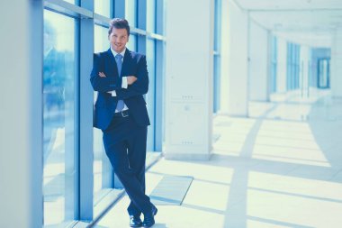 Ofisteki pencerenin yanında duran işadamının portresi