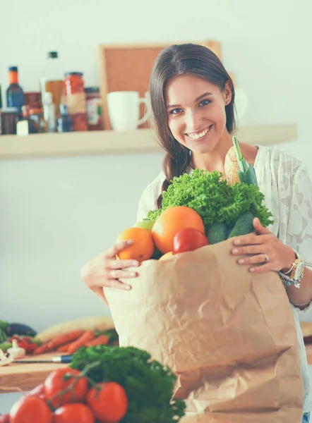 Young woman holding grocery shopping bag with vegetables — Stock Photo, Image