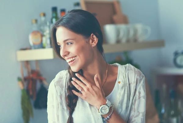 Jonge vrouw in de buurt van bureau in de keuken — Stockfoto