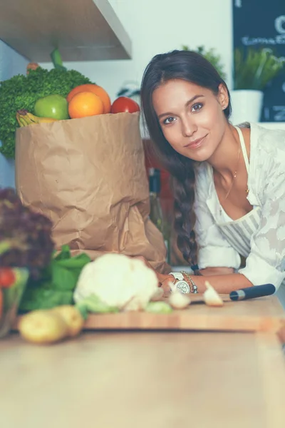 Young woman reading cookbook in the kitchen, looking for recipe — Stock Photo, Image