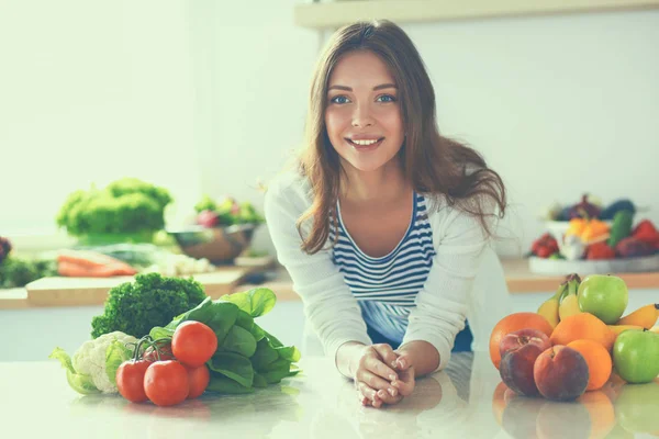 Jonge vrouw in de buurt van bureau in de keuken — Stockfoto