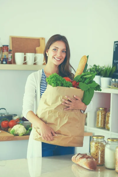 Young woman holding grocery shopping bag with vegetables — Stock Photo, Image