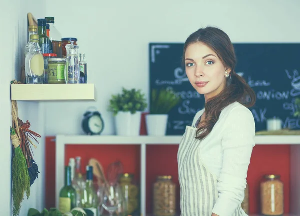 Ung kvinna står nära skrivbord i köket — Stockfoto
