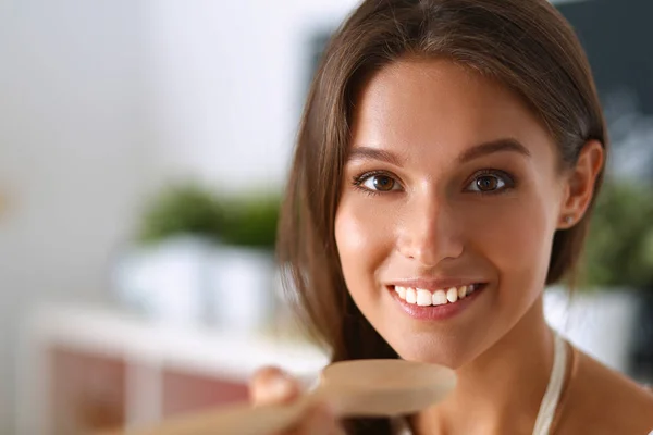 Young woman standing near desk in the kitchen — Stock Photo, Image