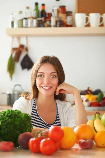 Jonge vrouw in de buurt van bureau in de keuken — Stockfoto