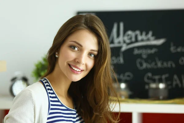 Giovane donna in piedi vicino alla scrivania in cucina — Foto Stock