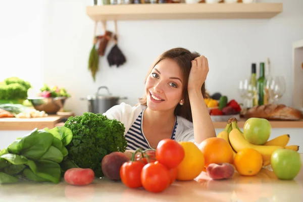 Junge Frau steht neben Schreibtisch in der Küche — Stockfoto