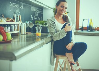 Mutfakta masada oturan genç bir kadın. .