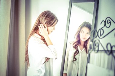 Genç kadın kendini evde aynada yansıma arıyor