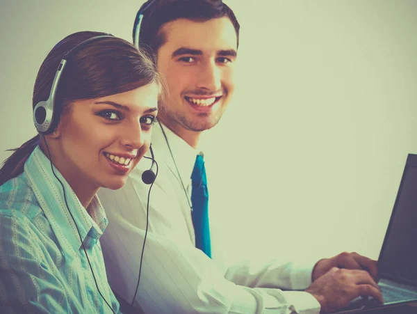 Jonge zakenvrouw en knappe zakenman in hoofdtelefoons met behulp van laptops terwijl u werkt in office — Stockfoto