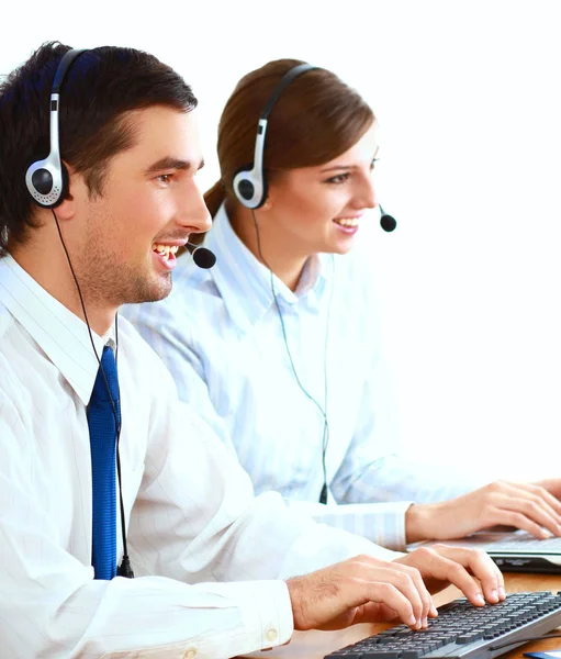 Young business woman and handsome businessman in headsets using laptops while working in office — Stock Photo, Image