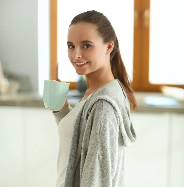Donna felice bere il tè in cucina a casa — Foto Stock