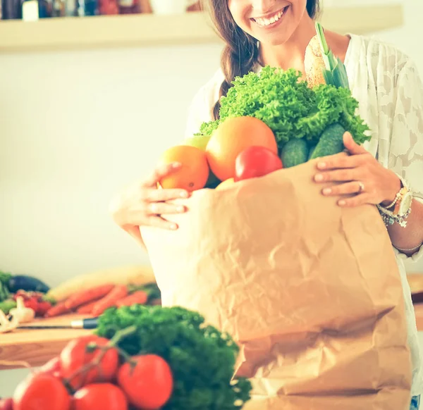 Young woman holding grocery shopping bag with vegetables — Stock Photo, Image