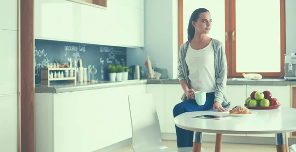 Mujer feliz bebiendo té en la cocina en casa —  Fotos de Stock