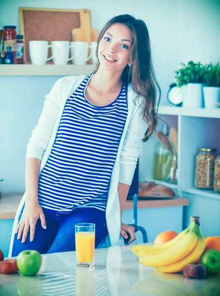 Junge Frau sitzt neben Schreibtisch in der Küche — Stockfoto