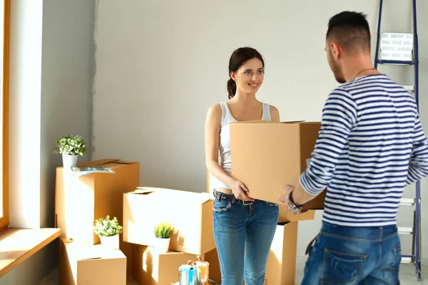Happy young couple unpacking or packing boxes and moving into a new home — Stock Photo, Image