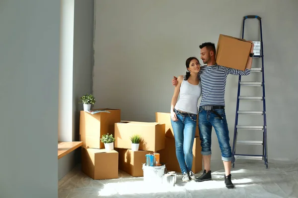 Happy young couple unpacking or packing boxes and moving into a new home — Stock Photo, Image