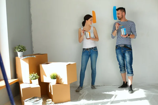 Portrait happy smiling young couple painting interior wall of new house — Stock Photo, Image