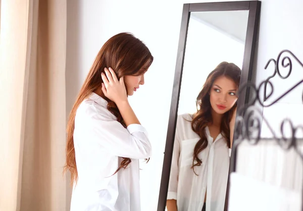 Mujer joven mirándose a sí misma reflejo en el espejo en casa — Foto de Stock