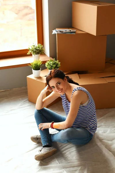Woman in a new home with cardboard boxes — Stock Photo, Image